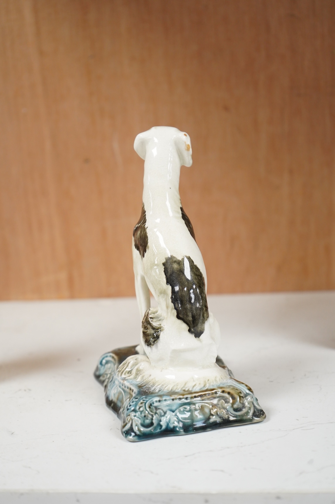 A Minton’s glazed pottery model of a seated Saluki, c.1905, stamped to the base, 15cm high
